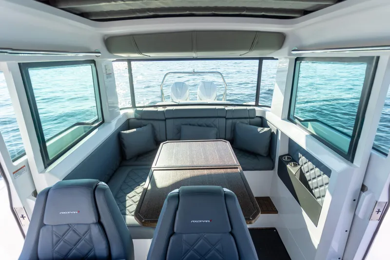 Slide: The Image of Interior of 2021 Axopar 37XC Aft Cabin with seating and table, overlooking water. - 21
