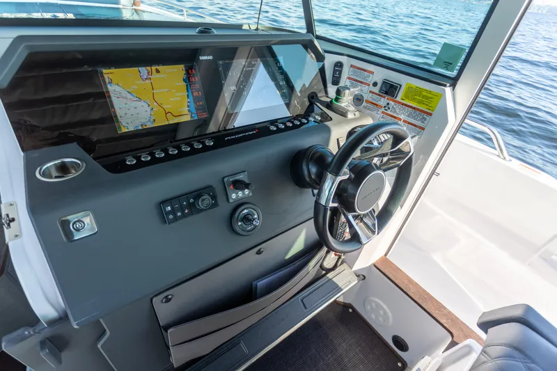 Slide: The Image of Helm of 2021 Axopar 37XC Aft Cabin with navigation display and steering wheel. - 23