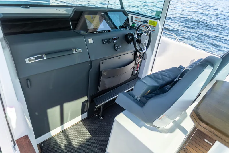 Slide: The Image of 2021 Axopar 37XC Aft Cabin helm with modern controls and ocean view. - 26