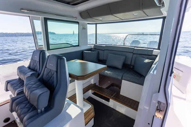 Slide: The Image of Interior of 2021 Axopar 37XC Aft Cabin with seating and table, overlooking the ocean. - 34