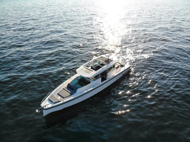 Slide: The Image of 2021 Axopar 37XC Aft Cabin cruising on open water, sunlight reflecting on waves. - 5