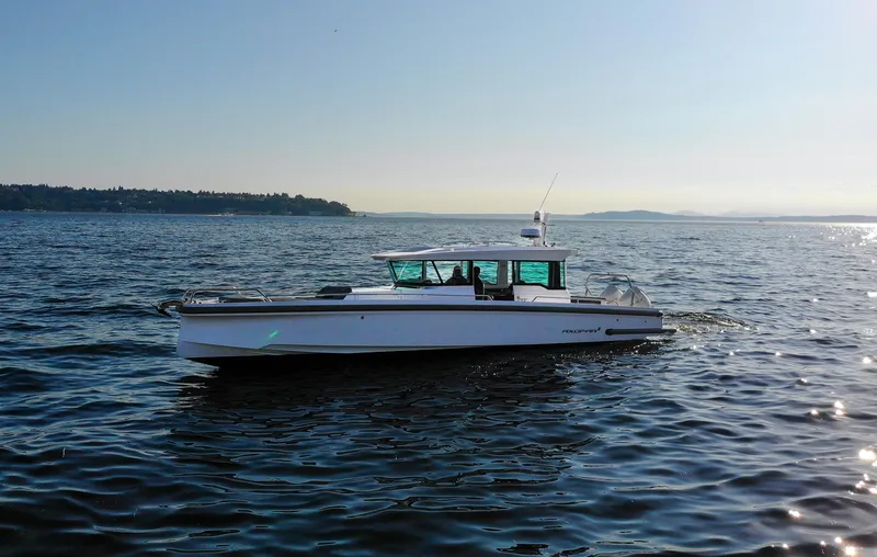 Slide: The Image of 2021 Axopar 37XC Aft Cabin boat cruising on open water under clear sky. - 6