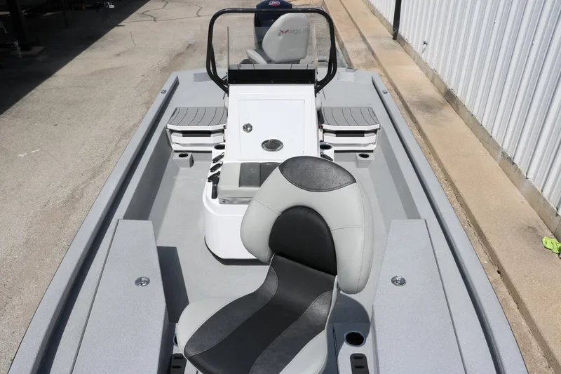 Slide: The Image of 2025 Vexus ACX 2000 boat interior with seating and console, parked outdoors. - 17