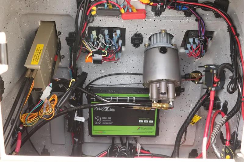 Slide: The Image of Electrical components inside a 2025 Vexus ACX 2000, featuring a battery charger and wiring. - 24