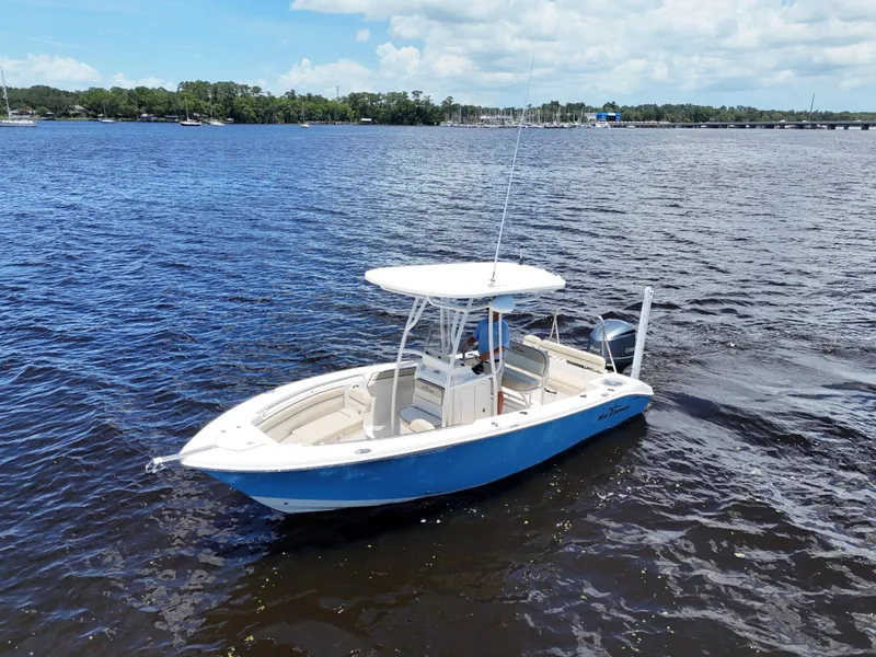 Slide: The Image of 2021 Carolina Skiff Sea Chaser 22 HFC boat on a sunny day, cruising on a lake. - 2