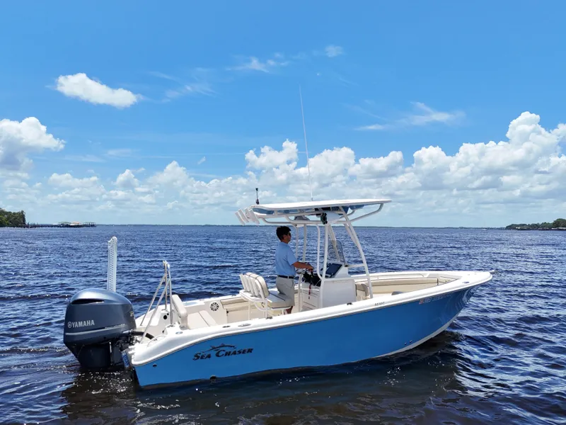 Slide: The Image of 2021 Carolina Skiff Sea Chaser 22 HFC boat on a sunny day, blue water background. - 9