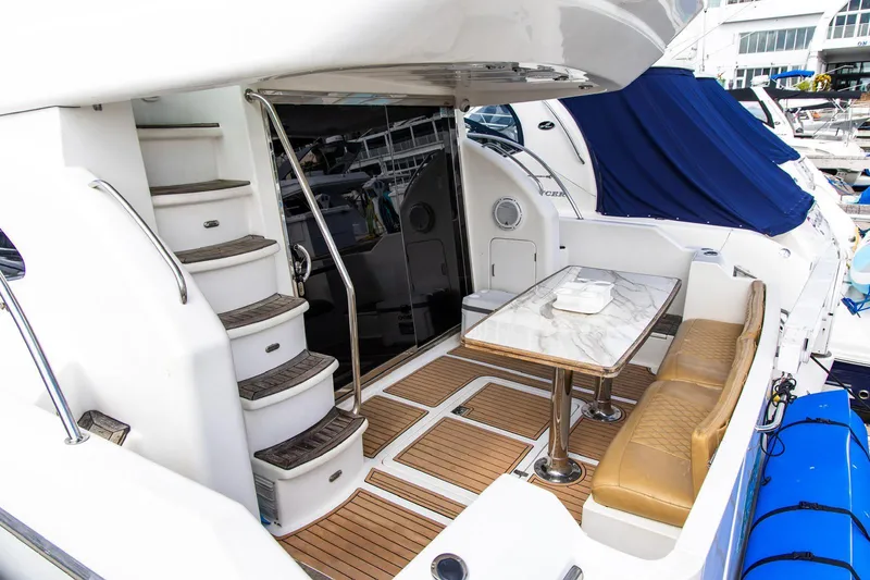 Slide: The Image of Luxurious 2002 Dyna 50 yacht deck with seating, table, and staircase. - 11