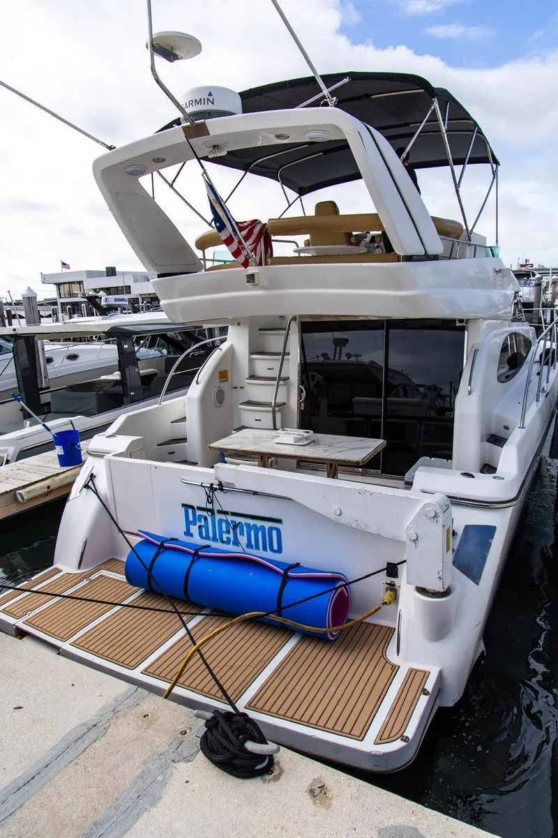 Slide: The Image of Luxury 2002 Dyna 50 yacht docked, featuring spacious deck and modern amenities. - 12