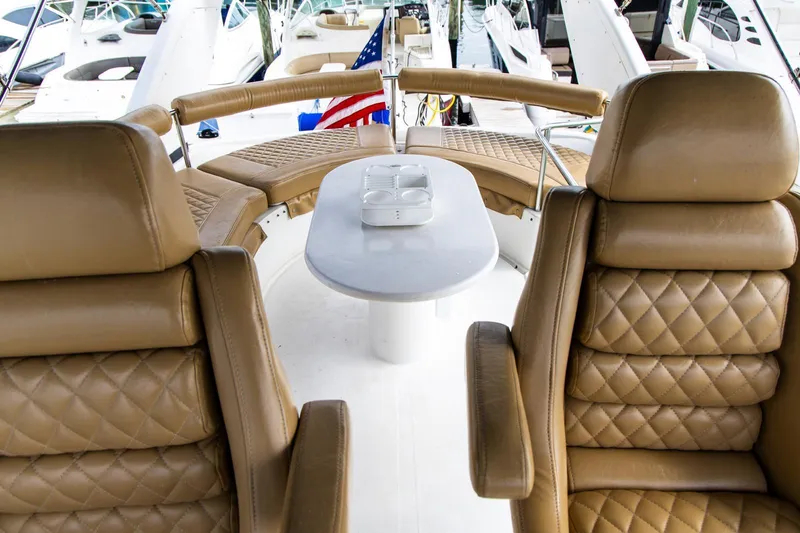 Slide: The Image of Luxurious seating on a 2002 Dyna 50 yacht with tan leather and a central table. - 20
