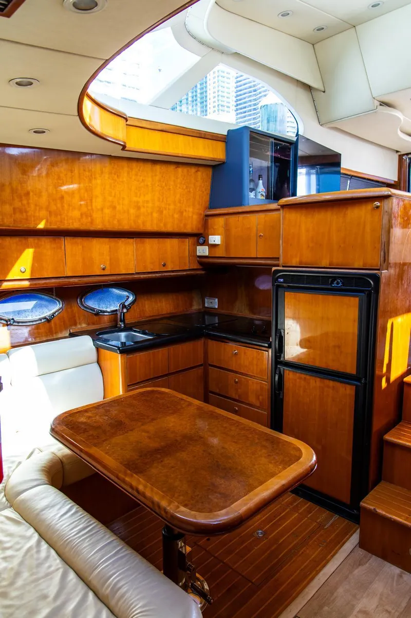 Slide: The Image of Luxurious 2002 Dyna 50 yacht interior with wooden cabinetry and compact kitchen area. - 24
