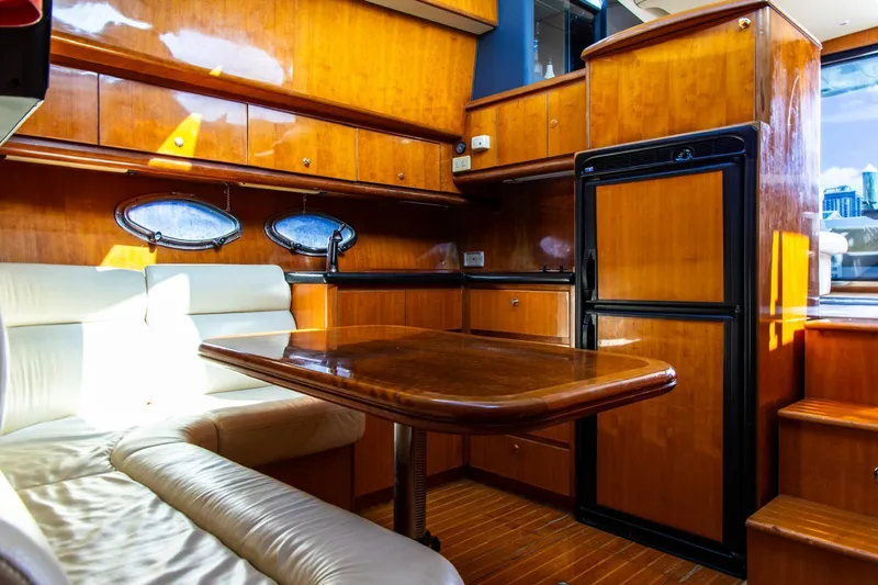 Slide: The Image of Luxurious 2002 Dyna 50 yacht interior with wooden cabinetry and plush seating. - 26