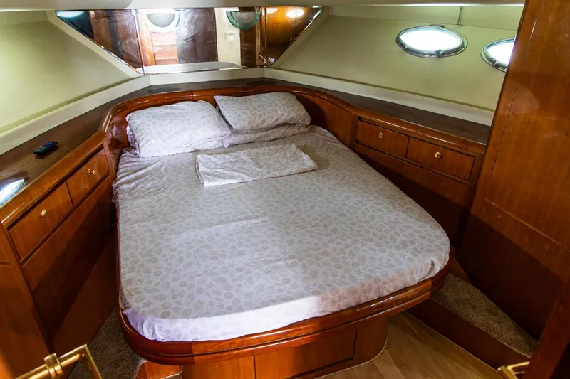 Slide: The Image of Luxurious cabin bedroom in 2002 Dyna 50 yacht with wooden furnishings and cozy bedding. - 28