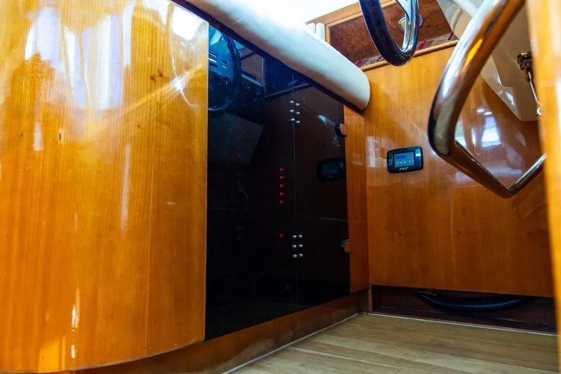 Slide: The Image of Interior of a 2002 Dyna 50 yacht with polished wood paneling and steering wheel. - 30