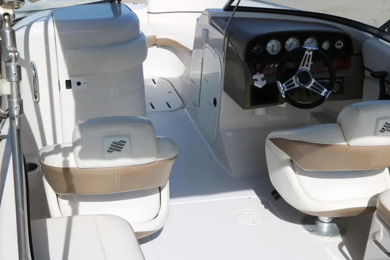 Slide: The Image of 2008 Four Winns 224 Funship boat interior with white and beige seating, steering wheel, and dashboard. - 12