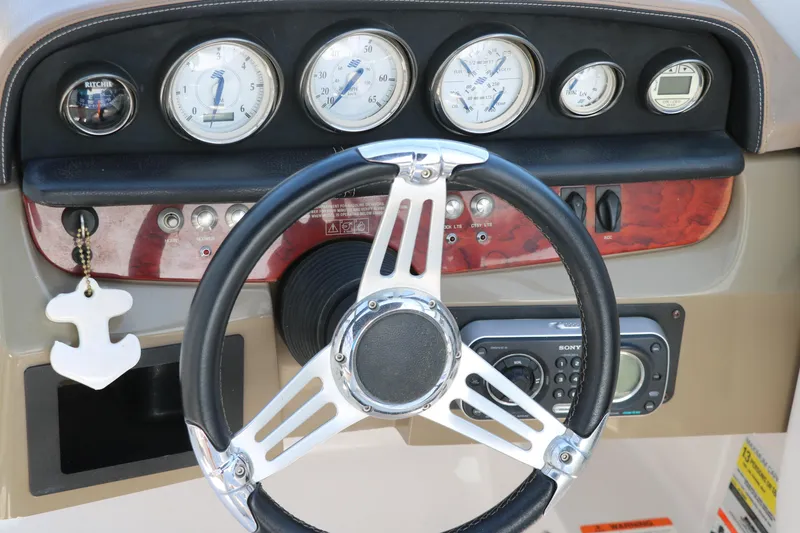 Slide: The Image of Steering wheel and dashboard of 2008 Four Winns 224 Funship boat with gauges and controls. - 27