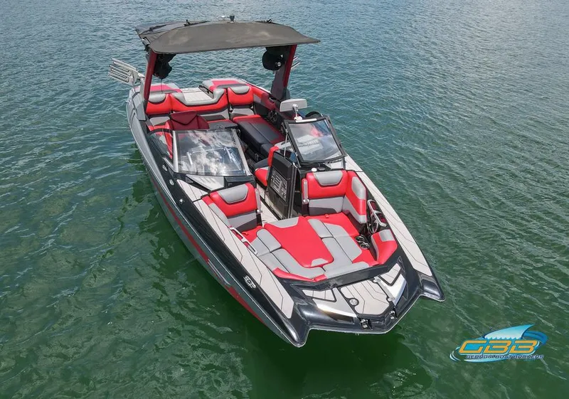 Slide: The Image of 2019 Malibu M235 boat with red and gray interior on calm water. - 10