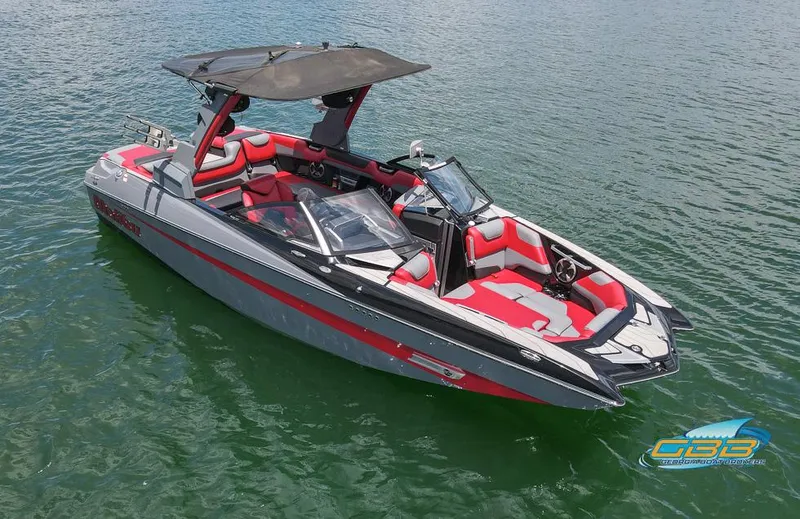 Slide: The Image of 2019 Malibu M235 boat with red and gray interior on calm water. - 11