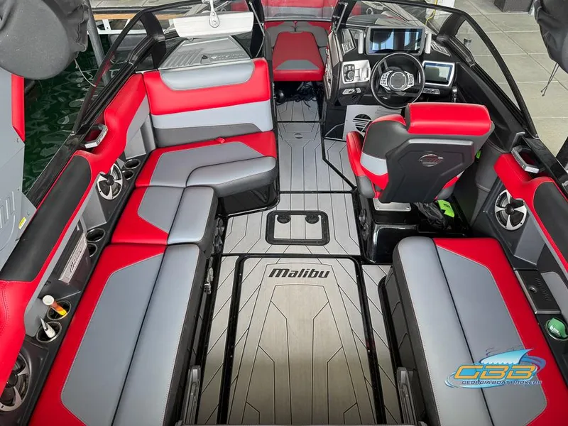 Slide: The Image of 2019 Malibu M235 boat interior with red and gray seating, modern dashboard, and spacious layout. - 15
