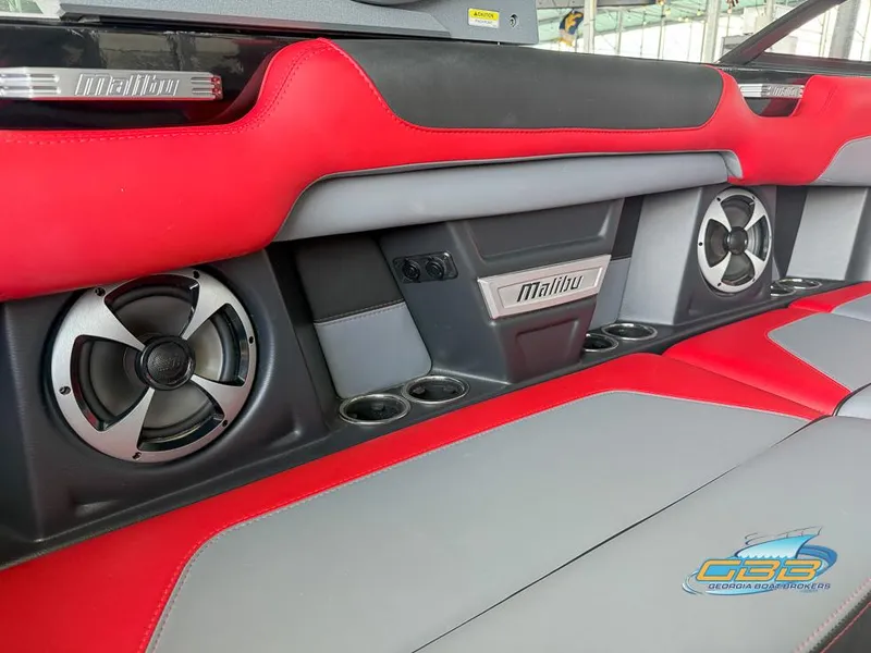 Slide: The Image of Red and gray interior of 2019 Malibu M235 boat with speakers and cup holders. - 23
