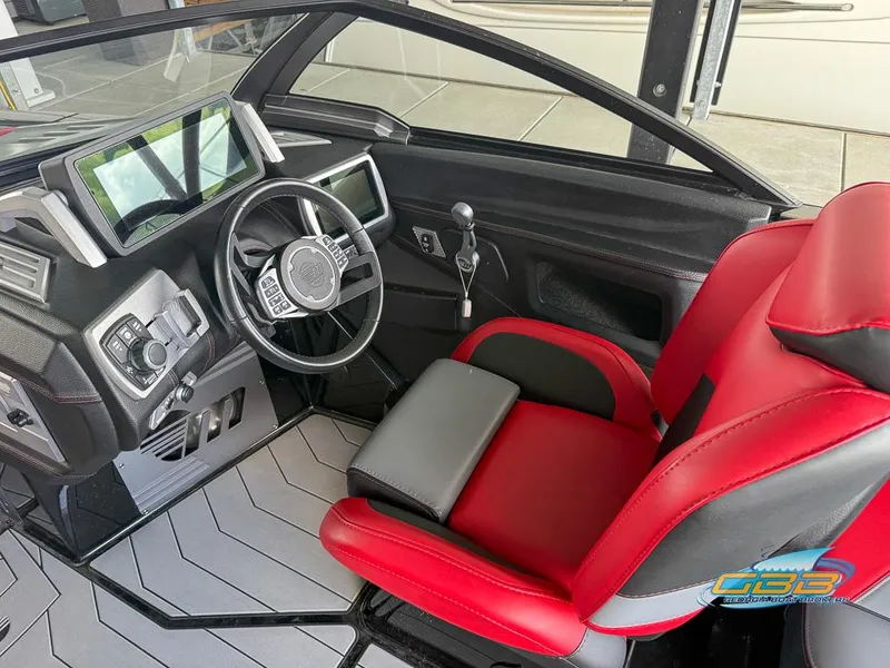 Slide: The Image of 2019 Malibu M235 boat interior with red and black seating, modern dashboard, and steering wheel. - 24