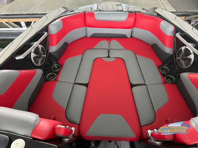 Slide: The Image of 2019 Malibu M235 boat interior with red and gray seating, cup holders, and speakers. - 25