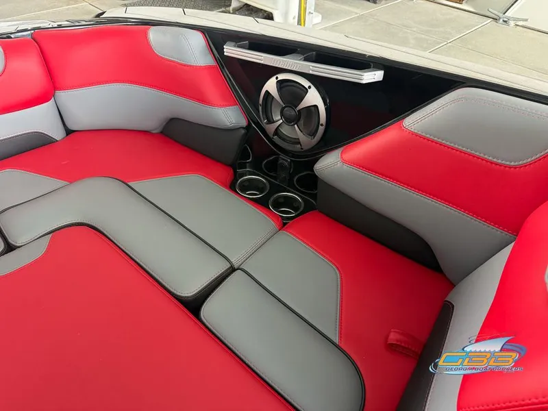 Slide: The Image of Red and gray interior seating of a 2019 Malibu M235 boat with speaker and cup holders. - 27