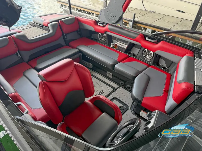 Slide: The Image of 2019 Malibu M235 boat interior with red and gray seating, featuring premium audio system. - 28