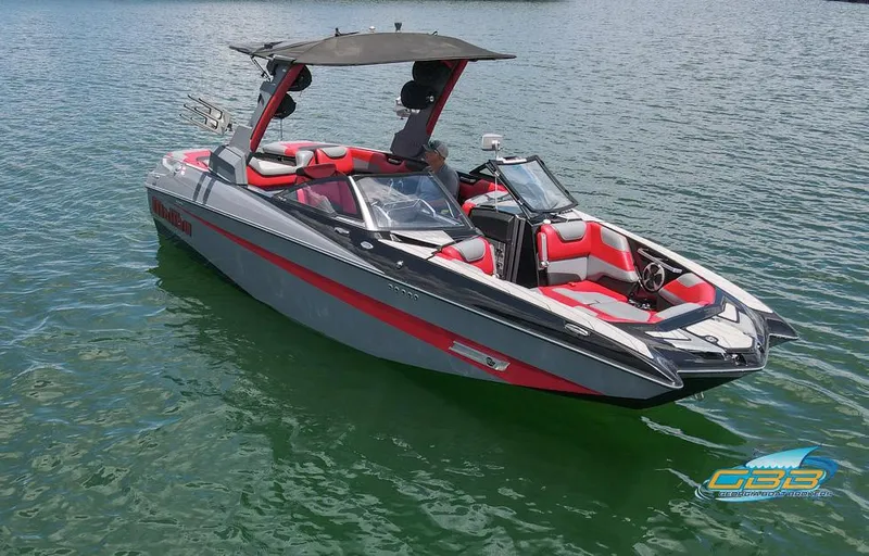 Slide: The Image of 2019 Malibu M235 boat with red and gray interior on a calm lake. - 3
