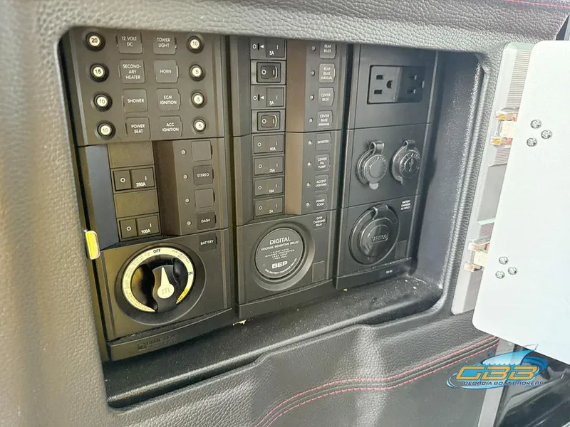Slide: The Image of Control panel of a 2019 Malibu M235 boat with various switches and outlets. - 32