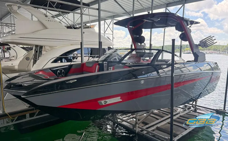 Slide: The Image of 2019 Malibu M235 boat with red accents docked in a marina. - 36