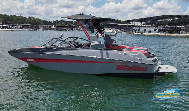 Slide: The Image of 2019 Malibu M235 boat on a lake with marina in background. - 7