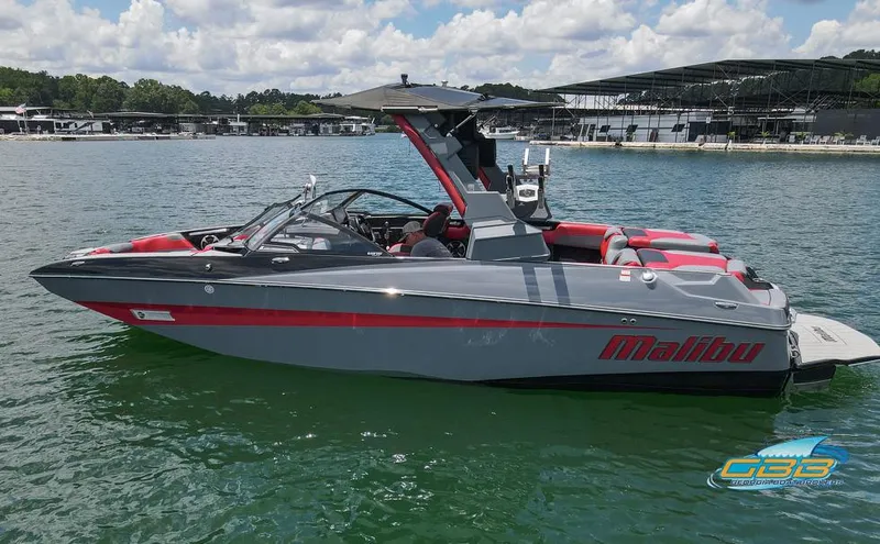 Slide: The Image of 2019 Malibu M235 boat on a lake, featuring sleek design and vibrant red accents. - 8
