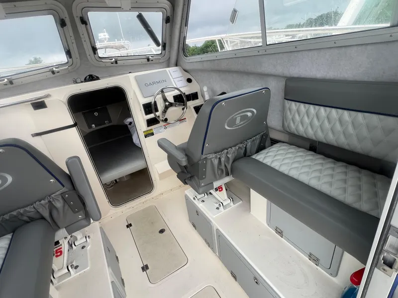 Slide: The Image of Interior of 2021 Defiance Admiral 250 EX boat with seating and steering console. - 20