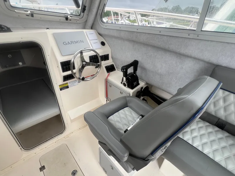 Slide: The Image of Interior of 2021 Defiance Admiral 250 EX boat with Garmin navigation system and cushioned seating. - 24