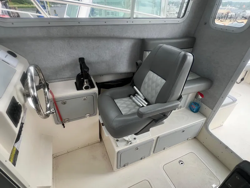 Slide: The Image of Interior of 2021 Defiance Admiral 250 EX boat with steering wheel and captain's chair. - 26