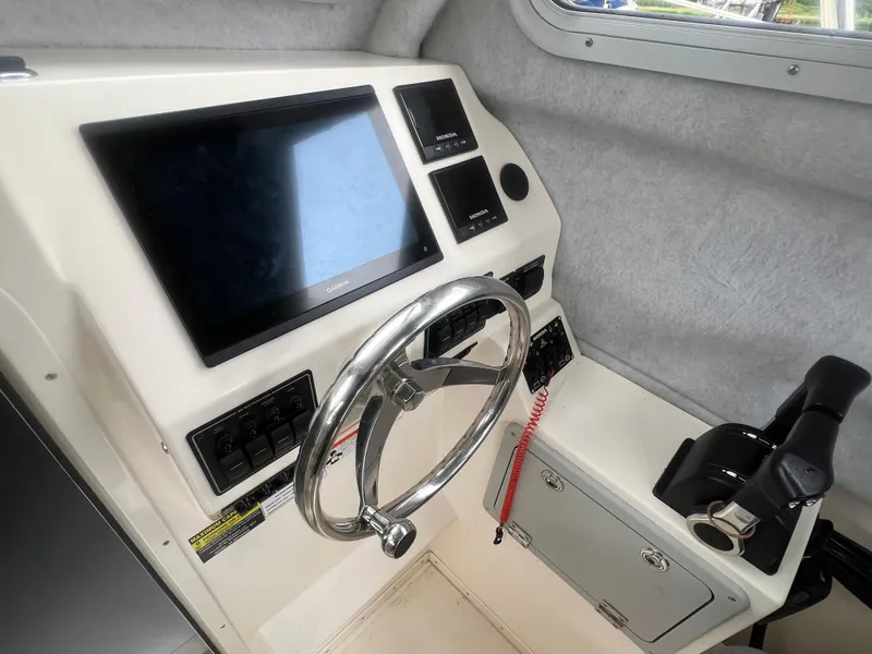 Slide: The Image of 2021 Defiance Admiral 250 EX helm with steering wheel, Garmin display, and control panel. - 27
