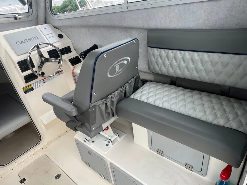 Slide: The Image of Interior of 2021 Defiance Admiral 250 EX boat with steering wheel and seating. - 31