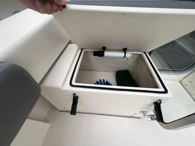 Slide: The Image of Open storage compartment on 2021 Defiance Admiral 250 EX boat, showing interior contents. - 35