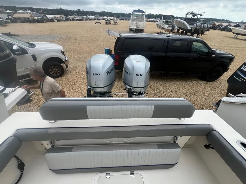 Slide: The Image of 2021 Defiance Admiral 250 EX boat with dual Honda 150 engines in a boatyard setting. - 37