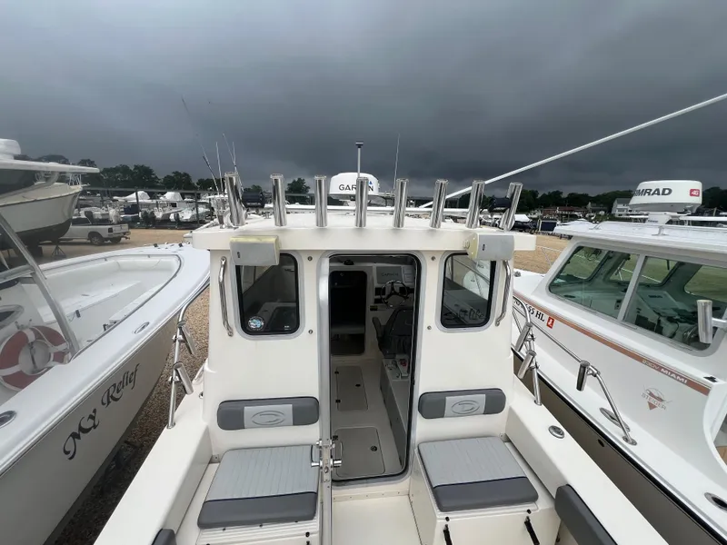 Slide: The Image of 2021 Defiance Admiral 250 EX boat docked under stormy skies. - 38