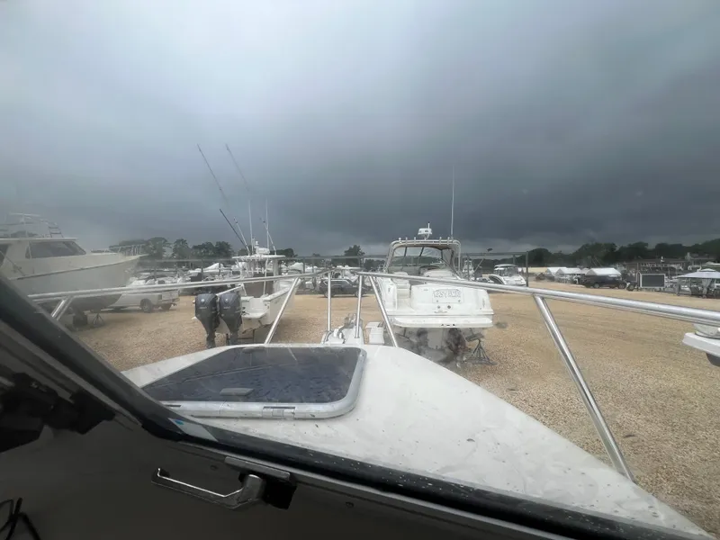 Slide: The Image of 2021 Defiance Admiral 250 EX boat on gravel lot under cloudy sky. - 39