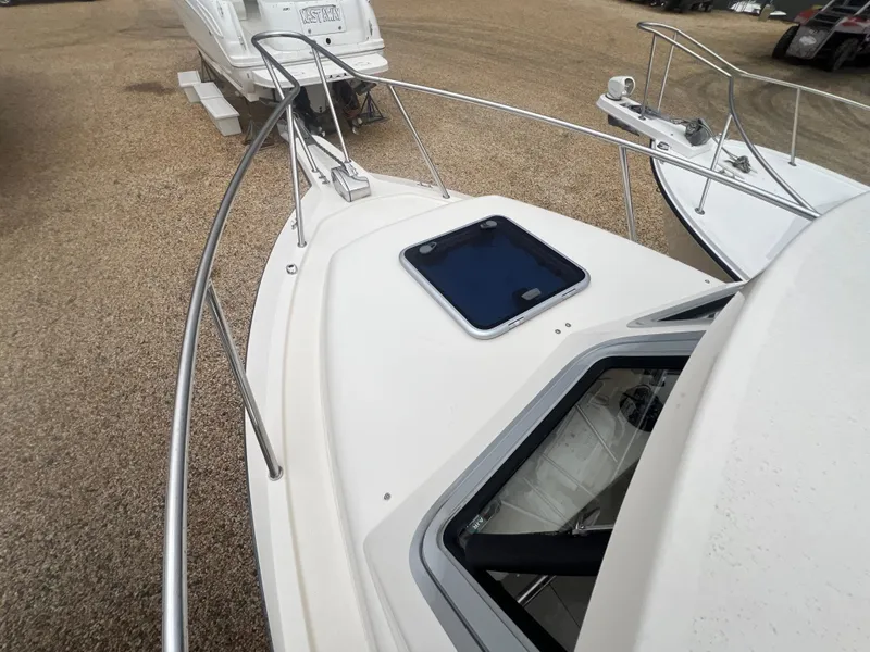 Slide: The Image of 2021 Defiance Admiral 250 EX boat deck with railing and hatch, parked on gravel. - 40