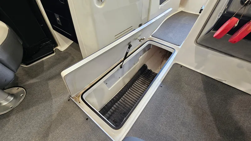 Slide: The Image of 2020 Yamaha SX240 boat interior storage compartment open, showcasing spacious design. - 23