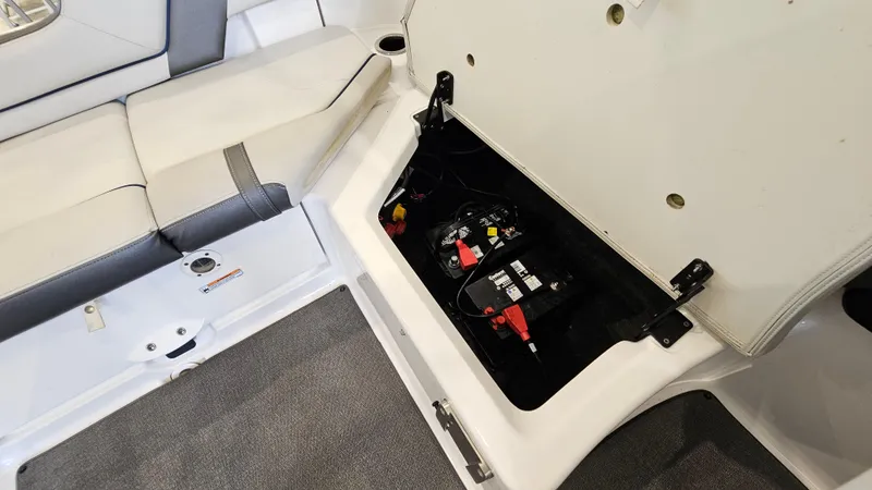 Slide: The Image of 2020 Yamaha SX240 boat battery compartment with open hatch and seating area. - 25