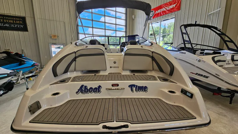 Slide: The Image of 2020 Yamaha SX240 boat in showroom, rear view with seating and deck. - 5