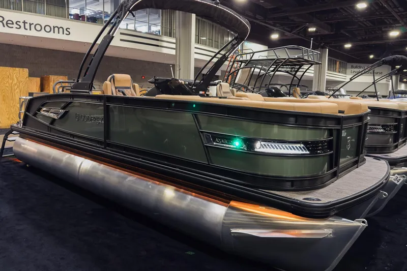 The Image of 2026 Godfrey AquaPatio 23' Flip Lounge Tritoon displayed indoors, showcasing sleek design and modern features. - 0