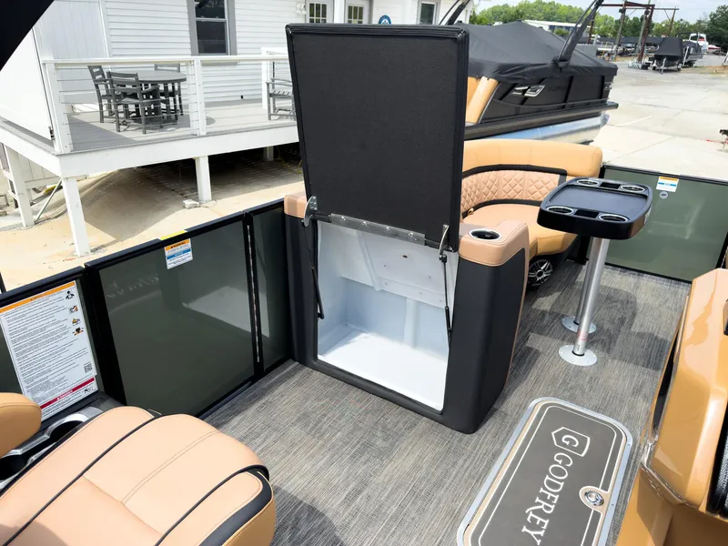 Slide: The Image of 2026 Godfrey AquaPatio 23' Tritoon interior with flip lounge and storage compartment. - 54
