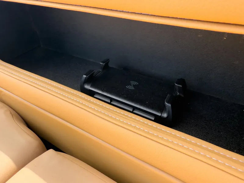 Slide: The Image of Storage compartment with wireless charging pad in Godfrey AquaPatio 23' Flip Lounge Tritoon, 2026 model. - 65