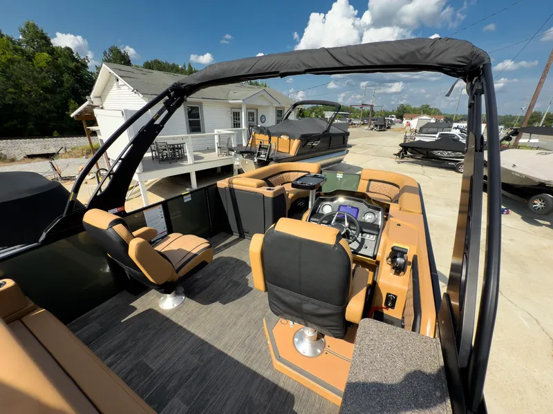 Slide: The Image of 2026 Godfrey AquaPatio 23' Flip Lounge Tritoon with modern seating and controls, docked outdoors. - 73