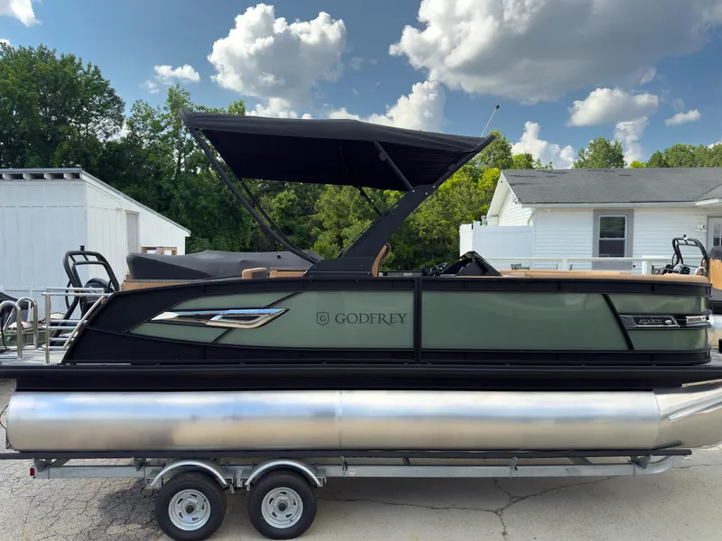 Slide: The Image of 2026 Godfrey AquaPatio 23' Flip Lounge Tritoon on trailer, under a partly cloudy sky. - 79